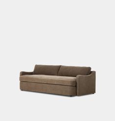 a brown couch sitting on top of a white wall