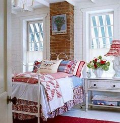 a bed room with a neatly made bed and a red rug on the floor in front of two windows