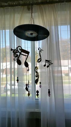 a wind chime hanging in front of a window with music notes and musical symbols