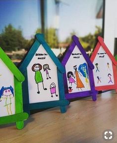 colorful paper houses with children's drawings on them are lined up against a wall