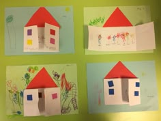 four different houses made out of paper on a green wall with children's drawings