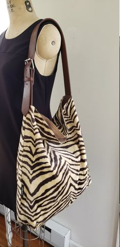 Take this bag with you where ever you go this season. Beautiful shoulder tote / hobo tote bag / bucket tote. FABRIC: Brown beige zebra LINING : Cotton canvas Adjustable Vegan leather shoulder strap that looks like real leather, with metal buckle. Large inside pocket for your cell phone and keys. Open top bag but deep enough to keep your valuables safe. Width: 18 inches Height 16 inches Bottom depth 4 inches Adjustable shoulder strap. Made in Newark, New Jersey by Kirtam Designs Inc. Hand wash an Bag Lining, Bucket Tote Bag, Buckle Bag, Hobo Tote Bag, Zebra Animal, Bucket Tote, Zebras Animal, Handbag Outfit, Brown And Beige