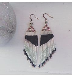 a pair of earrings with black, white and red beads hanging from it's hooks