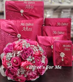 a bouquet of pink roses sits in front of the bride's gifts