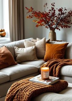 a living room filled with lots of pillows and blankets on top of a white couch