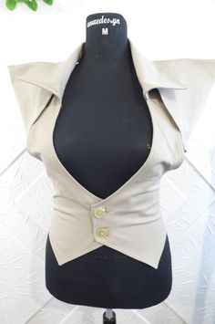 Stylish women's vest in beige color with additional parts.  The model can be made in other colors. Available sizes - IZE-EU-XXS-34 Bust-78cm.-80cm. Waist-58cm.-62cm. Hips - 84cm.-88cm. SIZE-USA-0 Bust -30.50in.-31in. Waist- 22.50in.-24in. Hips-33in.-34.50in. --------------------------------------------------- ------------------------------------ SIZE-EU-XS-36 Bust-81cm.-85cm. Waist-64cm.-67cm. Hips -88cm.-91cm. SIZE-USA-2 Bust-32in.-33.50in. Waist -25in.-26in. Hips-34.50in.-35.50in --------------------------------------------------- -------------------------------- SIZE-EU-S-37-38 Bust - 85cm.-89cm. Waist - 67cm.-71cm. Hips-91cm.-95cm. SIZE-USA-4 Bust -33in.-35in. Waist-26in.-28in. Hips-35.50in.-37.50in. --------------------------------------------------- ---------------------------------- Taupe Fitted Sleeveless Top, Fitted Taupe Sleeveless Top, Fitted Sleeveless Taupe Top, Fitted Beige Vest Outerwear, Beige Fitted Vest Outerwear, Chic Stretch Beige Vest, Chic Beige Stretch Vest, Fitted Khaki Vest For Work, Fitted Sleeveless Top In Neutral Color