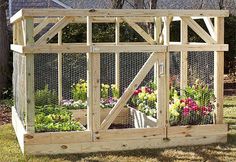 a chicken coop with flowers growing inside