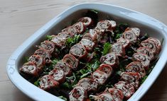 a dish filled with meat and vegetables on top of a wooden table