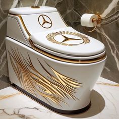 a white toilet with gold detailing in a bathroom