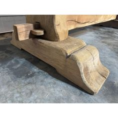 a bench made out of wood sitting on concrete