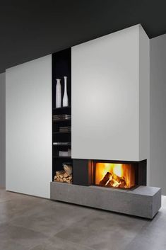 a fire place in the middle of a room with white walls and grey flooring