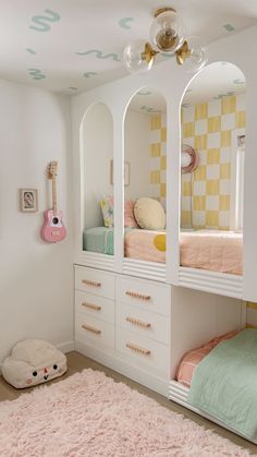 a child's bedroom with bunk beds, dresser and mirror