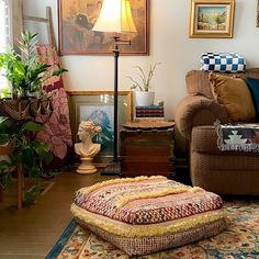 a living room filled with lots of furniture and pictures on the wall next to a lamp