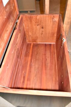 an open wooden box sitting on top of a table next to a wall and floor