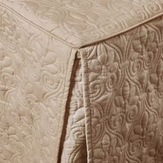 close up view of an unmade bed with the sheets pulled down and quilted