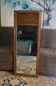 a mirror sitting on top of a floor next to a couch