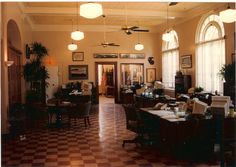 a large room with checkered flooring and lots of windows on the walls, along with two ceiling fans