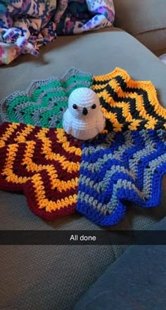 a stuffed animal laying on top of some crocheted blankets