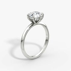 a white gold ring with an oval diamond in the center, on a plain surface