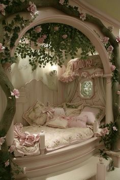 a white bed with pink flowers on the headboard