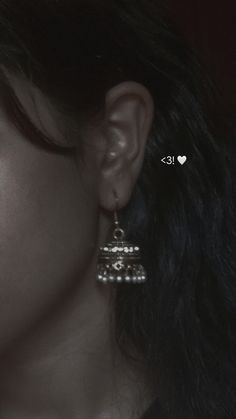 a close up of a person's ear wearing some kind of earrings with hearts on them