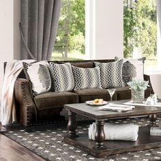 a living room filled with furniture and decor on top of a wooden floor next to a window