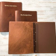 three brown leather folders sitting next to each other