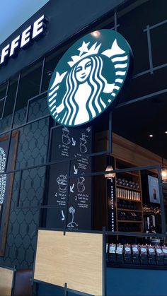 a starbucks sign on the side of a building with coffee written in arabic and english