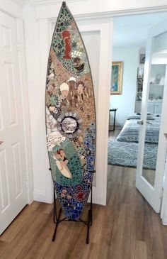 a surfboard is sitting on a stand in front of a door with a mirror behind it