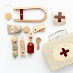 various wooden toys are laid out on a white surface, including an old fashioned sewing case