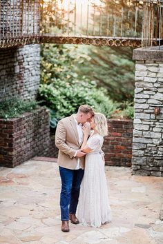 a bride and groom standing in front of an archway