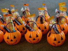 halloween candy in pumpkin shaped baskets on carpeted area with orange bags and candies