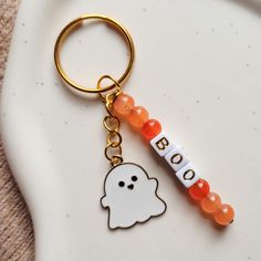 a keychain with a ghost on it and beaded beads around the neck