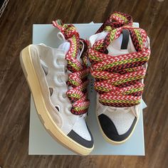 a pair of white sneakers with colorful shoelaces