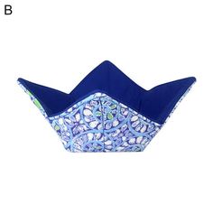 an origami boat with blue and white designs on the front, sitting against a white background