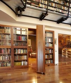 a room with wooden floors and bookshelves full of books