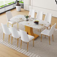 a dining table with white chairs around it