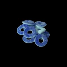 five blue donuts sitting on top of each other in front of a black background