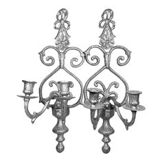 an old fashioned metal candelabra with candlesticks on the sides and two candle holders attached to it