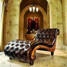 a brown leather chaise lounger sitting in a living room