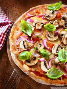 pizza with mushrooms, onions and spinach leaves