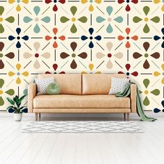 a couch sitting in front of a wall with geometric designs on it's sides