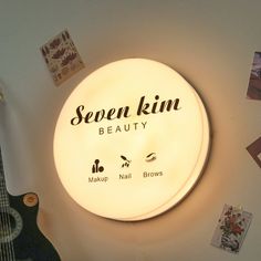 a lighted sign that says sepen kim beauty on the side of a wall next to a guitar