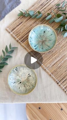 two bowls with plants in them sitting on top of a table