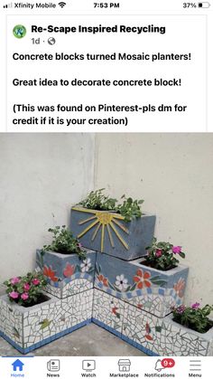 a bunch of planters that are made out of cement blocks with flowers on them