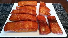 some salmons are on a white plate and ready to be cut into small pieces