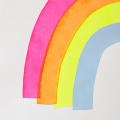 four different colored paper pieces are arranged in the shape of a rainbow on a white background