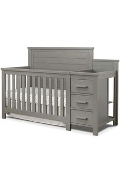 a gray crib with drawers and white sheets