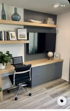 a desk with a laptop computer on top of it next to a plant and bookshelf