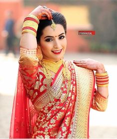 a woman in a red and gold outfit with her hands on her head, posing for the camera